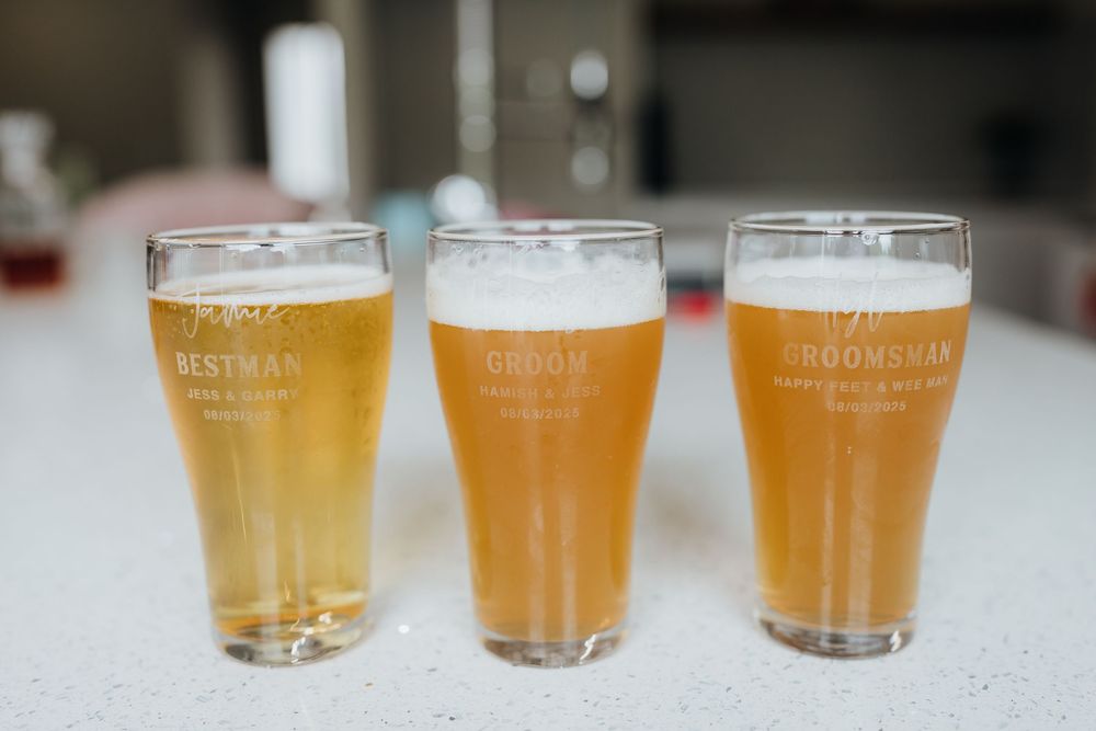 Row of golden beer glasses lined up on a white counter showing different shades of craft brew.