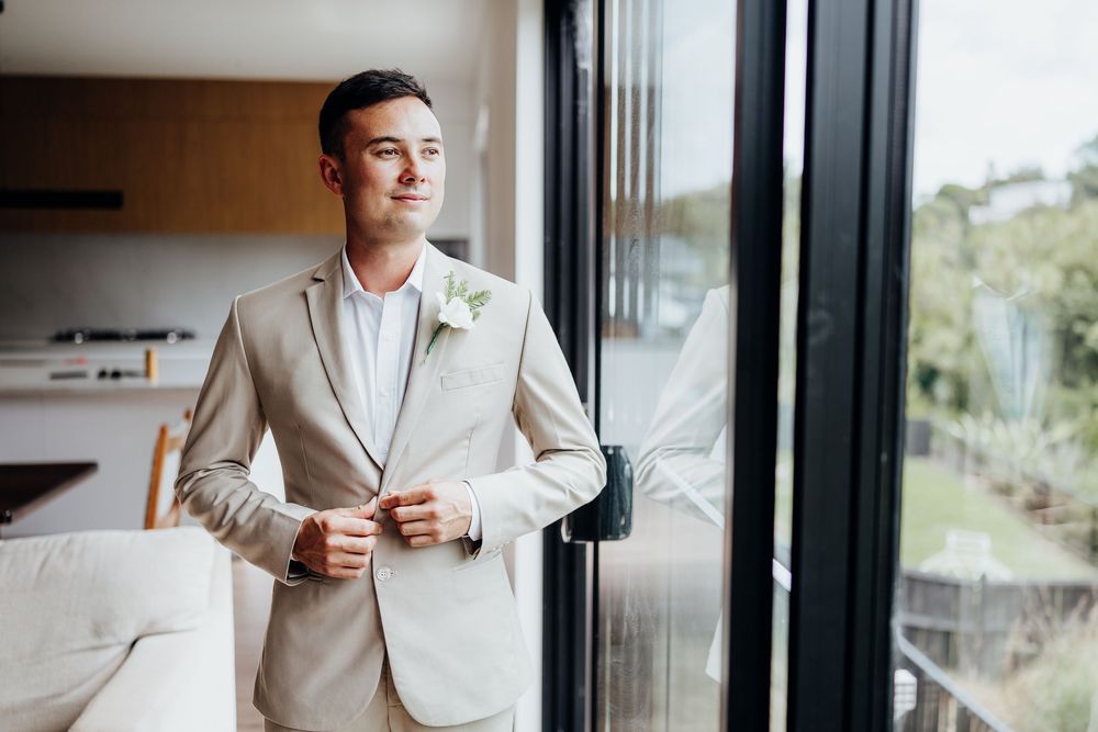 Person in light colored suit standing by window in preparation room.
