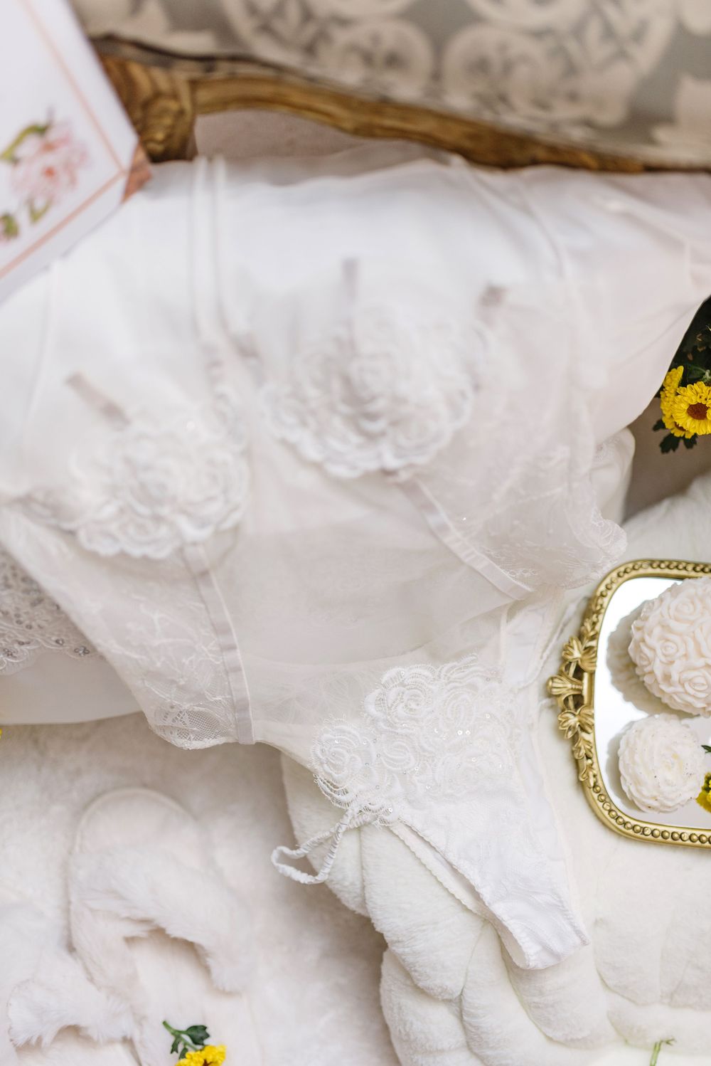 Delicate white lace fabric details with floral accents and vintage accessories.