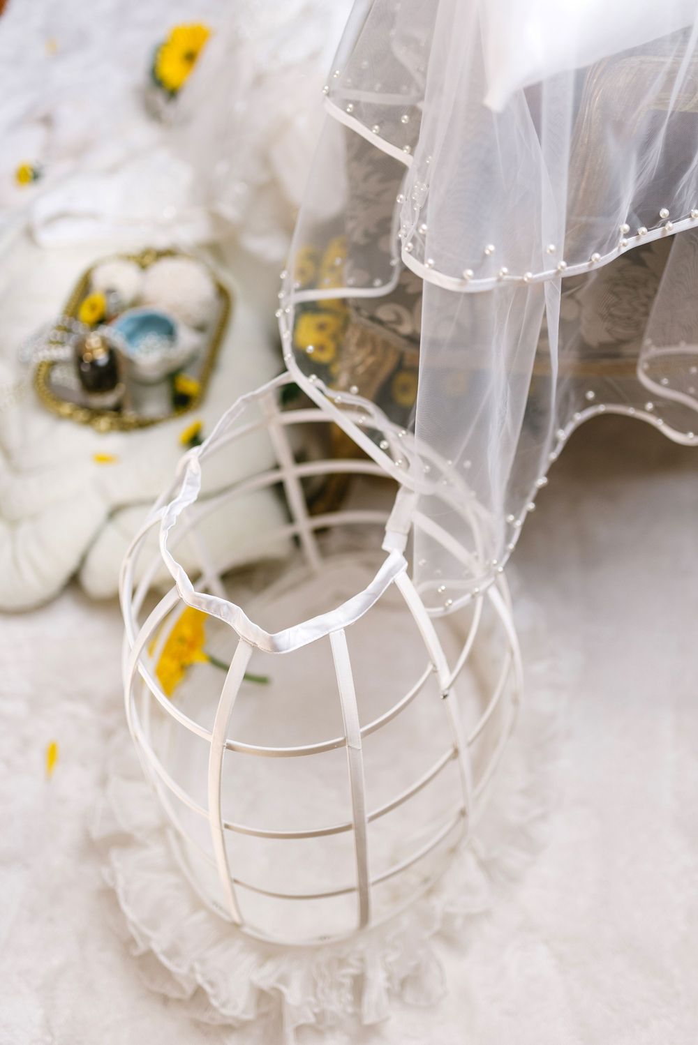 Close-up detail of delicate white lace and tulle fabric with decorative elements.