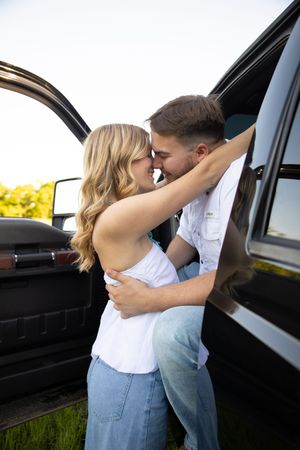 A romantic couple embraces and kisses against a car door in a series of connected photos.