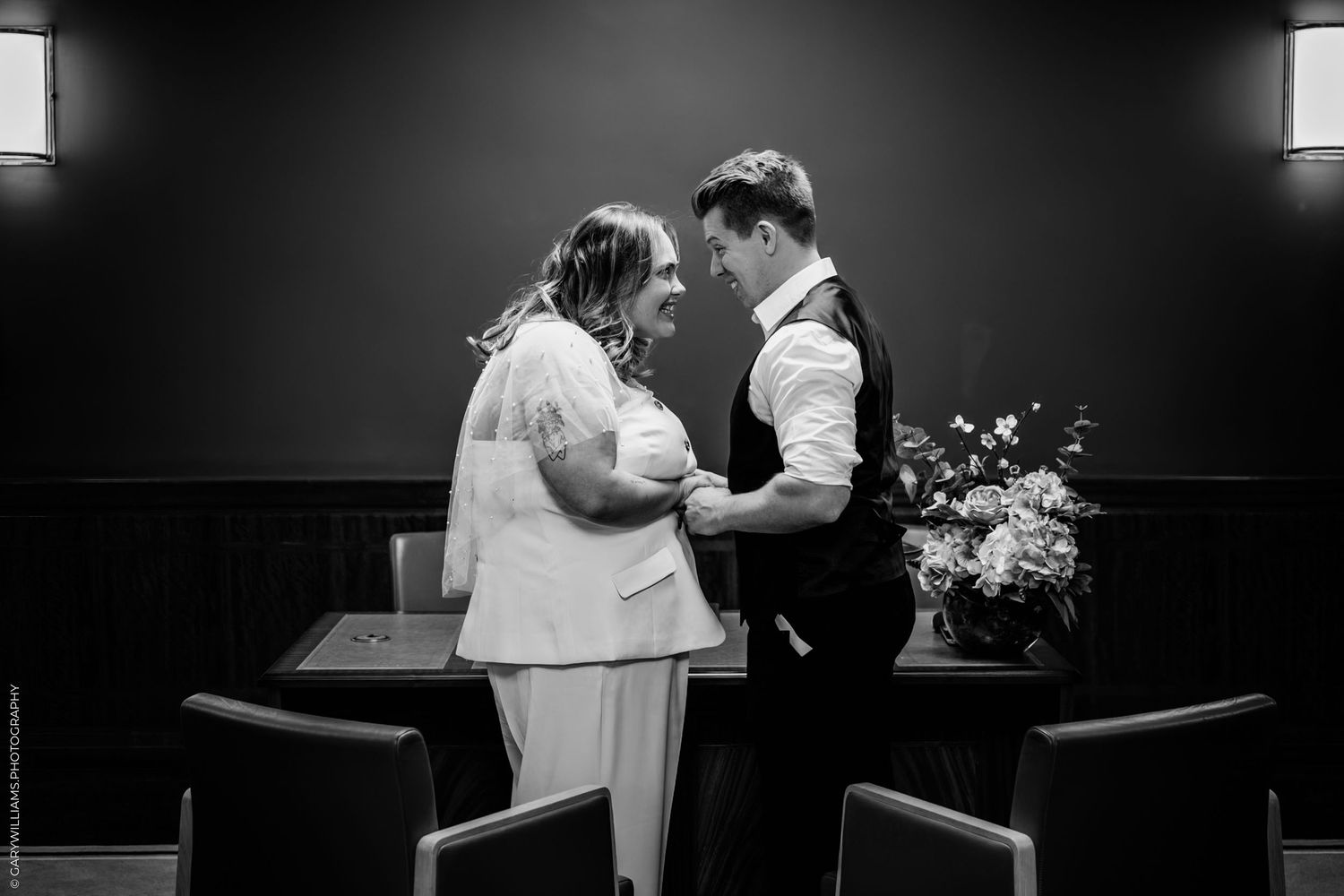 A tender black and white wedding moment captured between a couple during an intimate indoor ceremony.