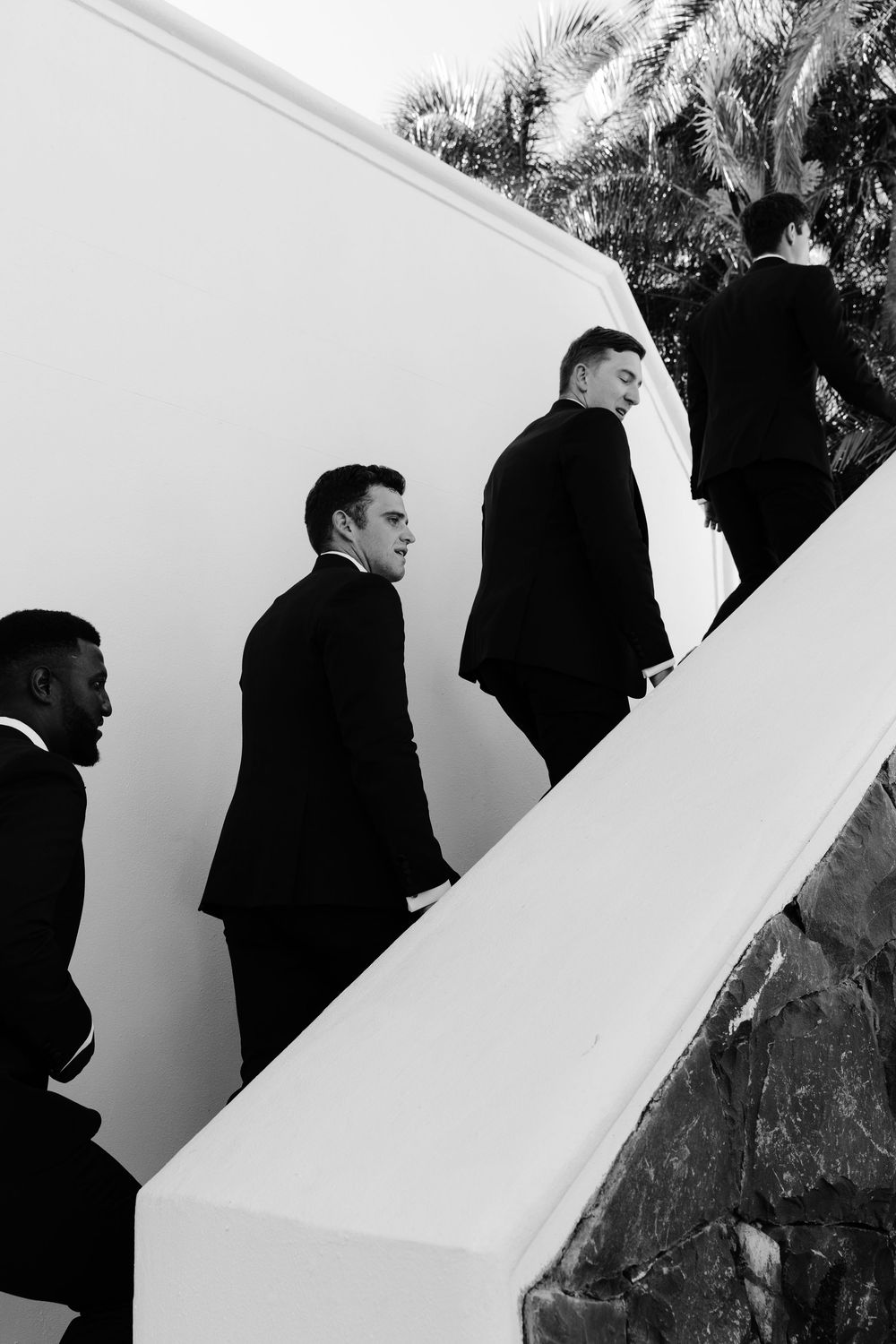 A black and white photo sequence shows a figure walking past a white wall in multiple frames.