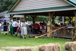 Rustic building exterior with green trim and wooden siding at an outdoor venue.