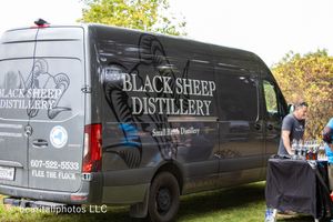 Black commercial vans with business logos parked at an outdoor event.