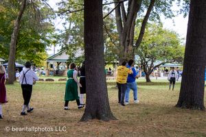 Trees and people scattered across a grassy outdoor event space.