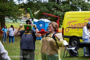 Colorful food trucks and vendor tents serving customers at an outdoor event.