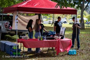 Red canopy tents and vendor displays set up at outdoor event.