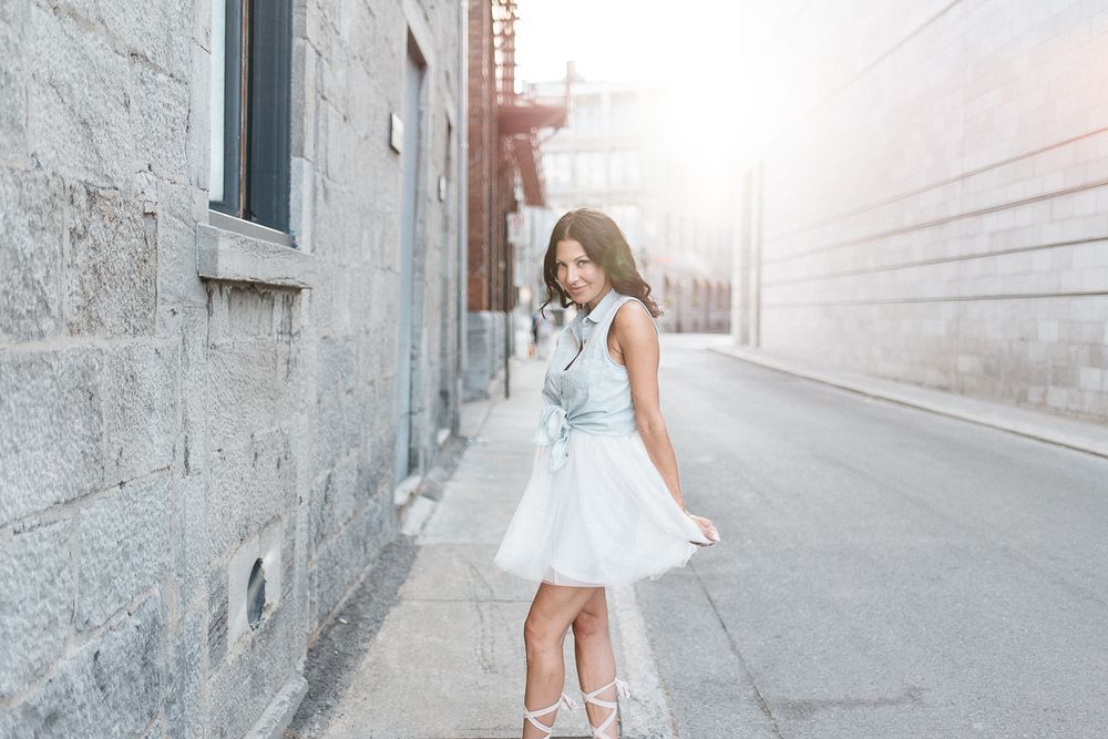 Portrait lifestyle en extérieur urbain, personne en robe blanche dans une ruelle lumineuse