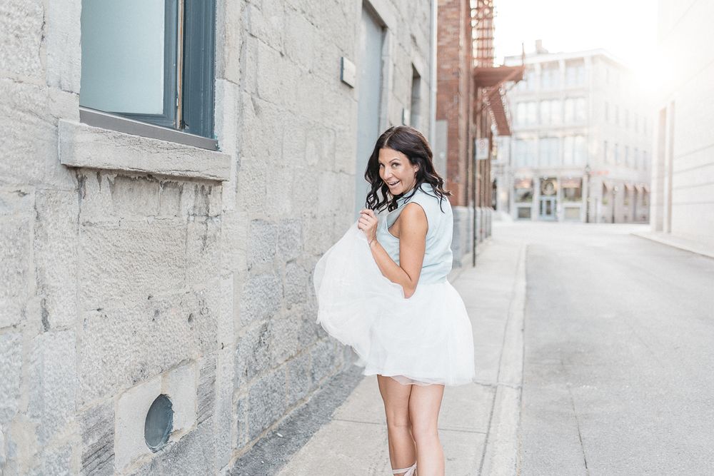 Portrait urbain en extérieur, personne en robe blanche dans une ruelle lumineuse