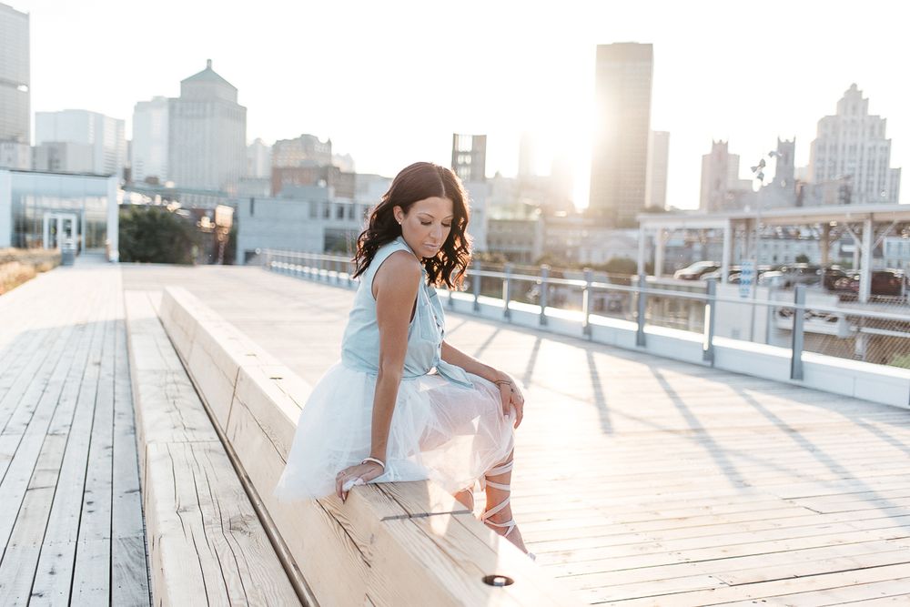 Portrait en extérieur urbain, personne assise sur un banc au soleil couchant