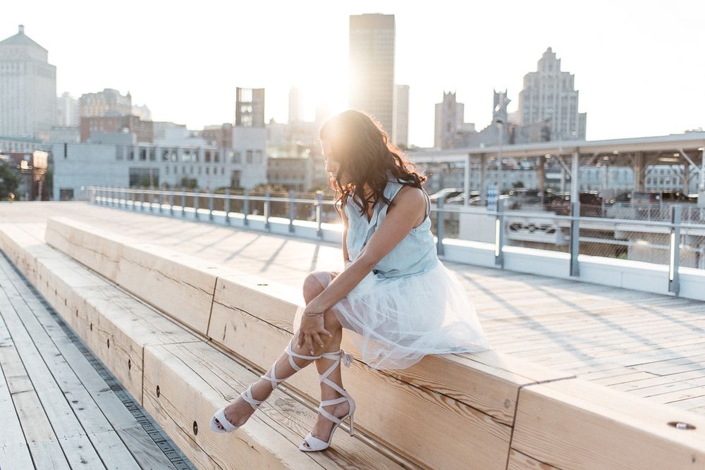 Séance portrait en lumière naturelle, personne assise sur un banc avec paysage urbain
