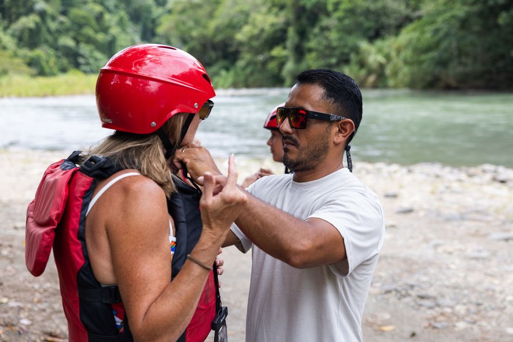 Safety briefing and equipment check before white water rafting expedition.