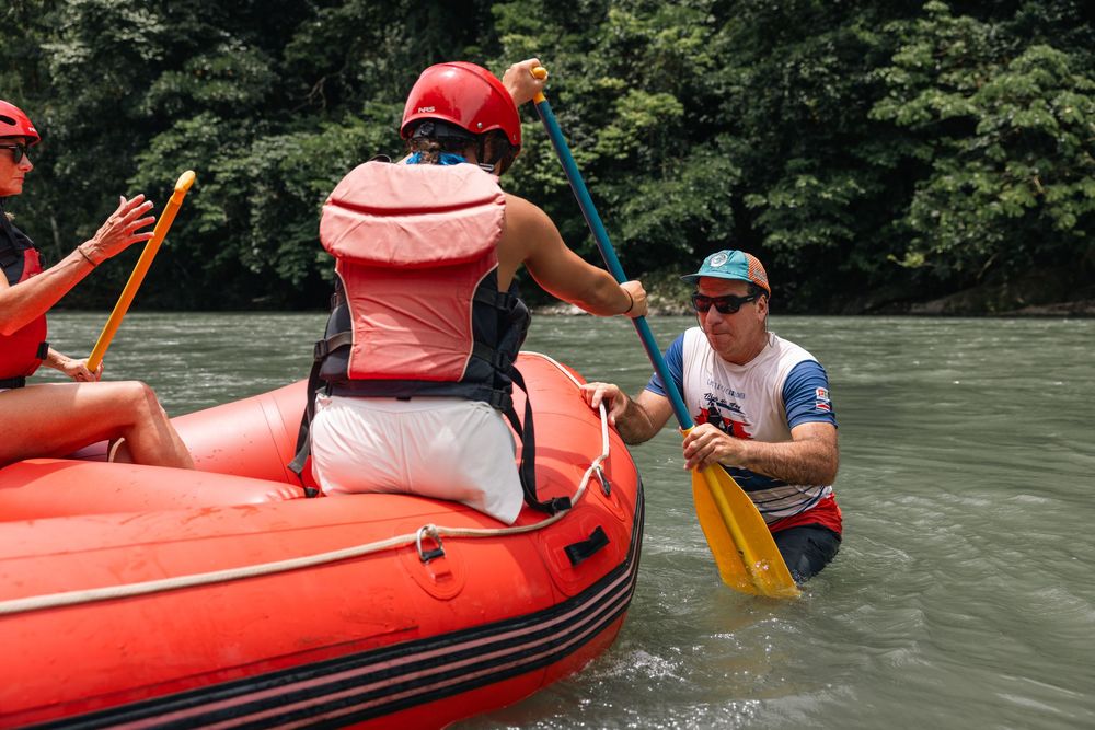 People paddling in bright red rafts during a river adventure.