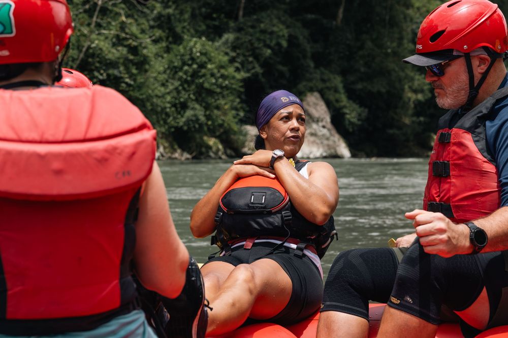 Adventurous rafters navigate through turbulent whitewater rapids in red rafts and blue kayaks.