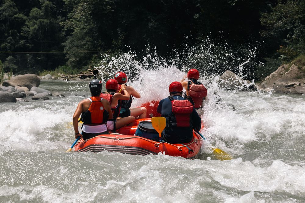 Red rafts plunge through powerful whitewater rapids creating dramatic splashes.