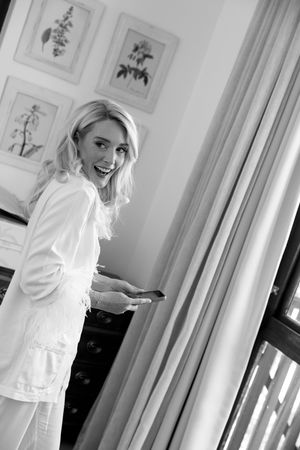 Black and white artistic portrait series showing a person in white clothing against a bright interior with window light.