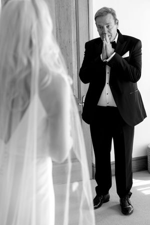 A series of black and white photos showing a person in a tuxedo crouching down and peeking through white curtains.