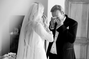Black and white wedding photos showing emotional first look moments between bride and groom in formal attire.