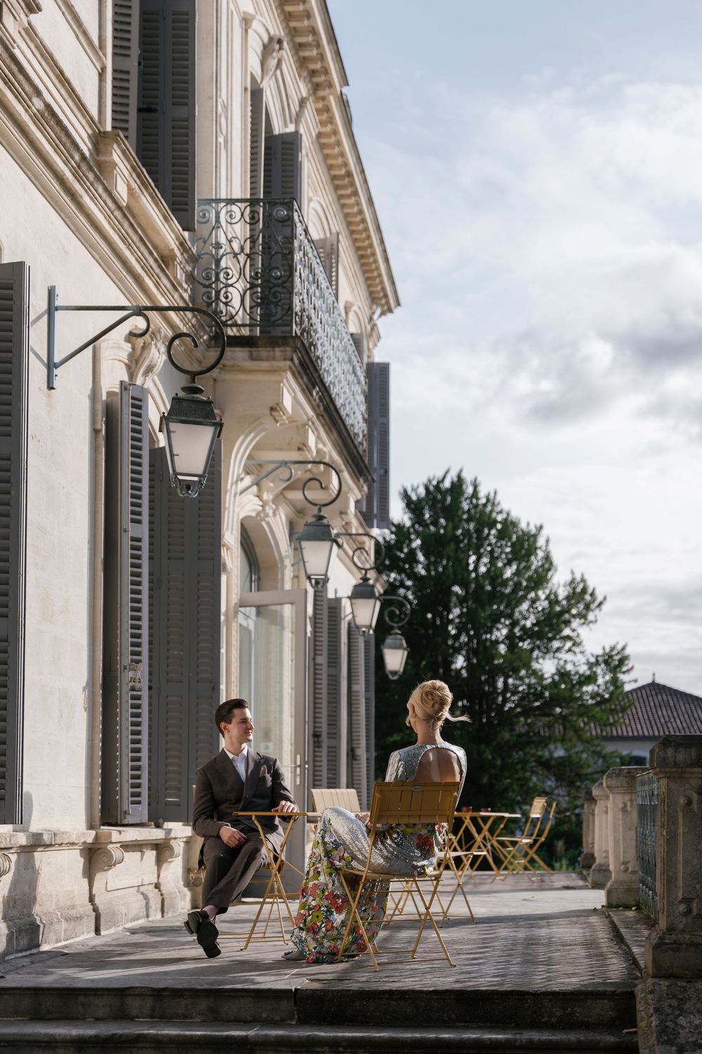 Elegant veranda of a French chateau with classic architecture and outdoor furniture.