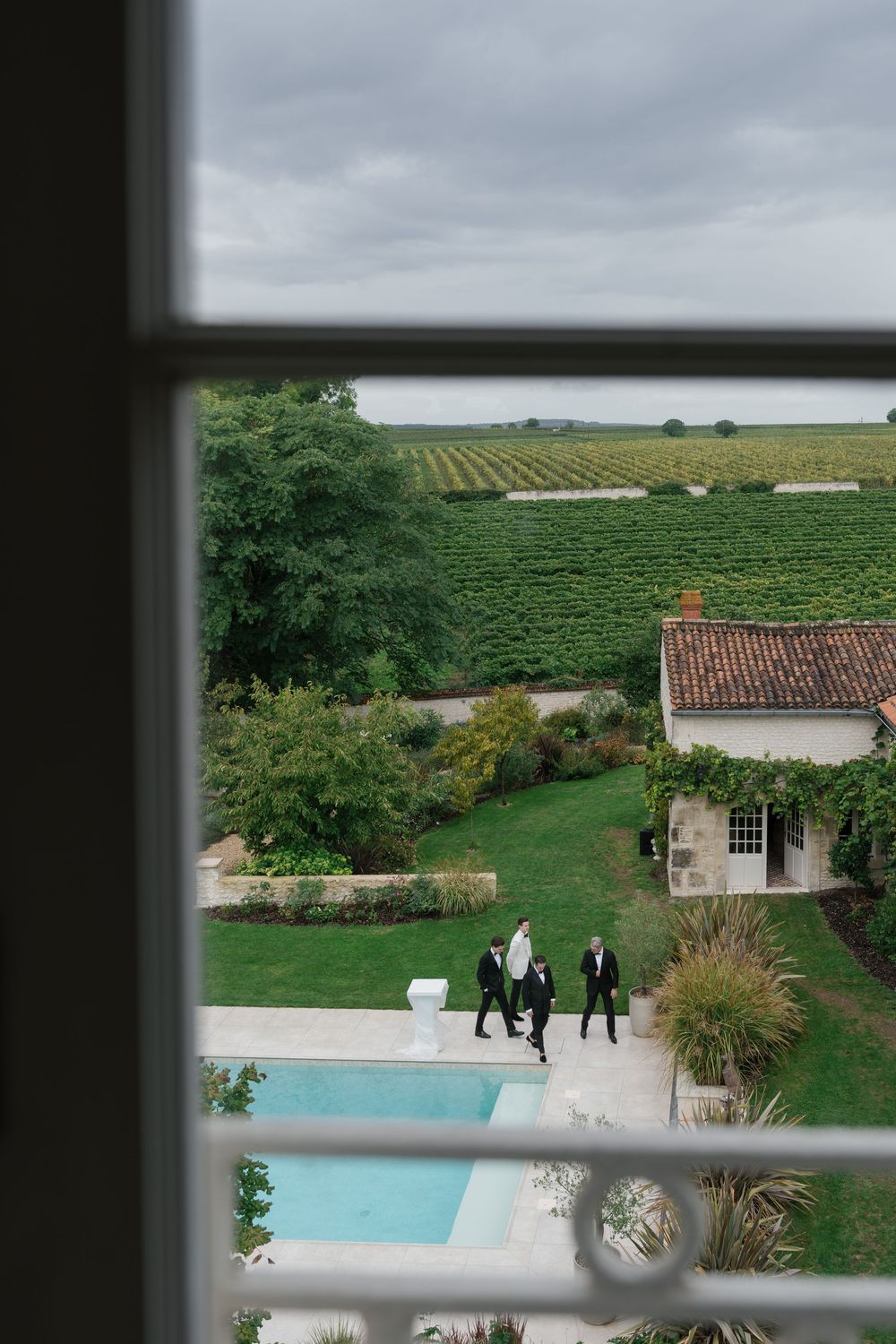 Aerial view of a luxury wedding venue with swimming pool and vineyard landscape in the countryside.