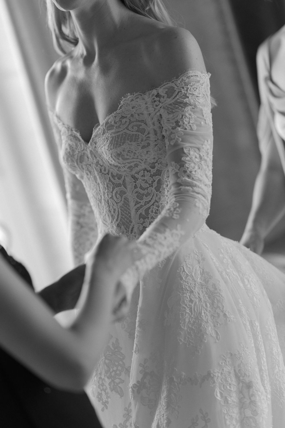 Close-up view of delicate white lace detailing on an elegant wedding dress bodice.