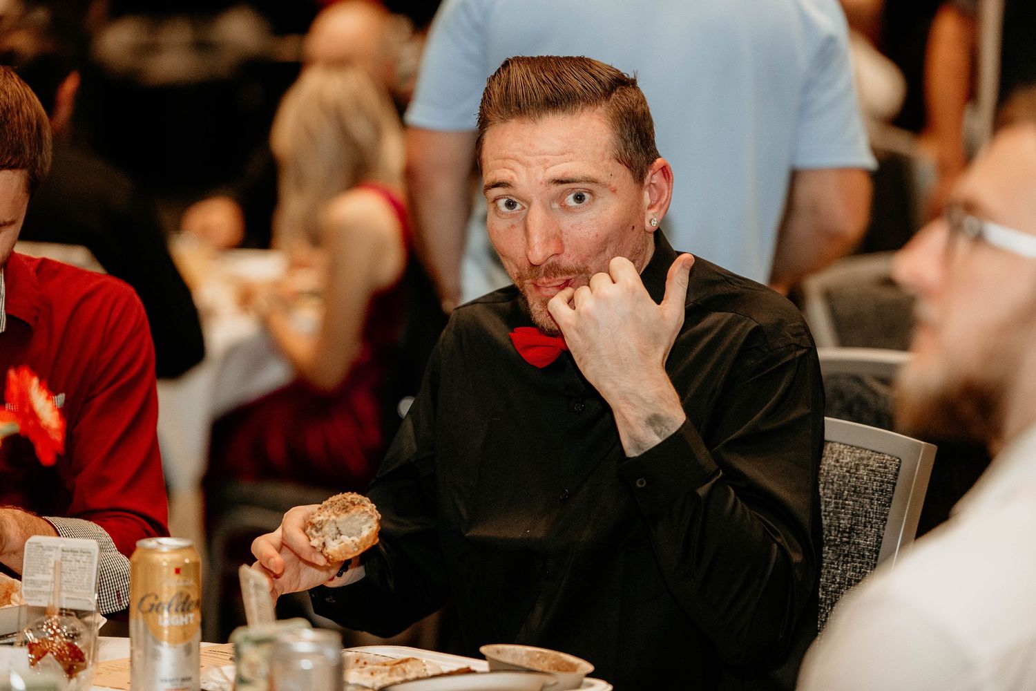A group of people laughing and enjoying themselves at a formal dinner event or reception.