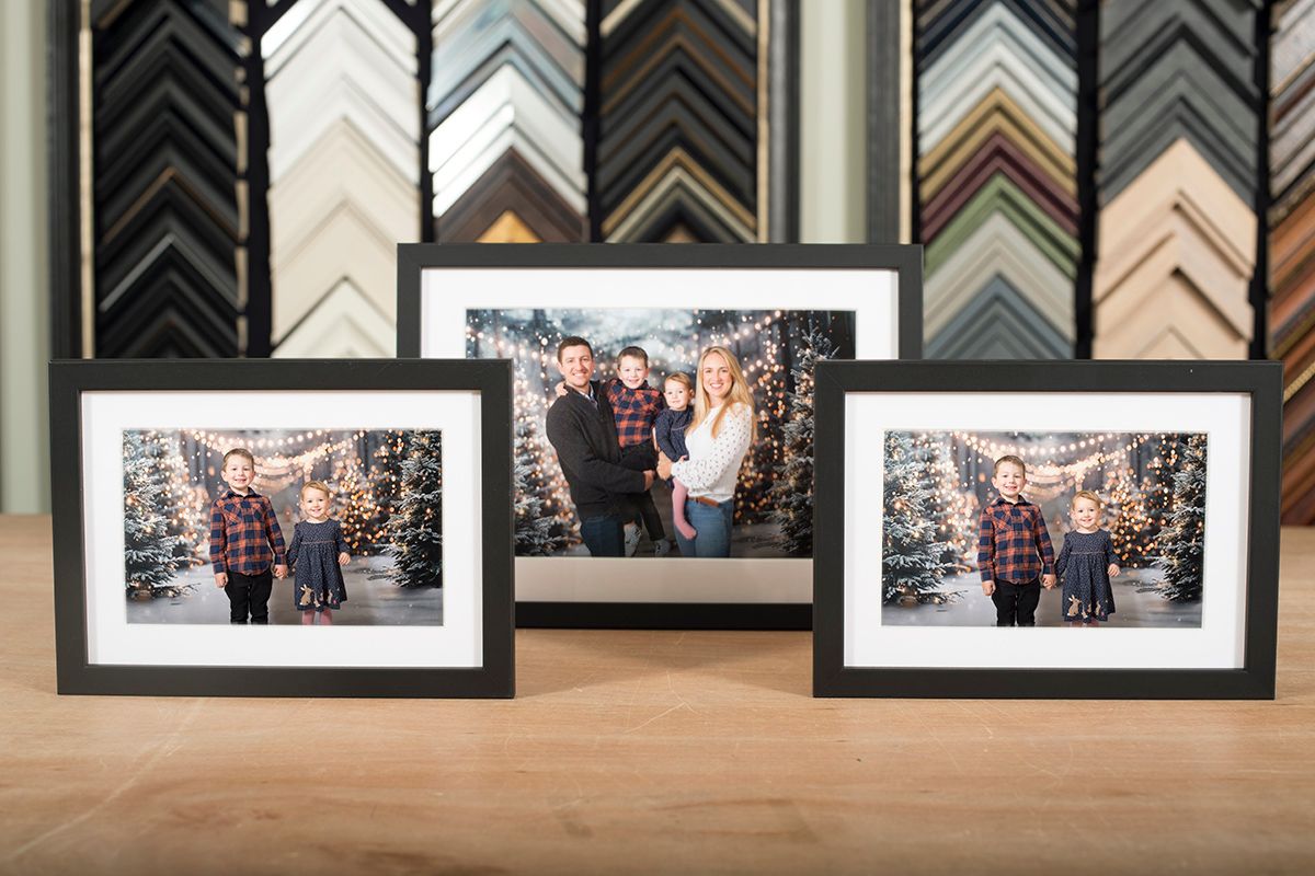 Close-up of framed prints and mounted family photos from the 2025 Christmas mini session pop-up studio in High Wycombe.