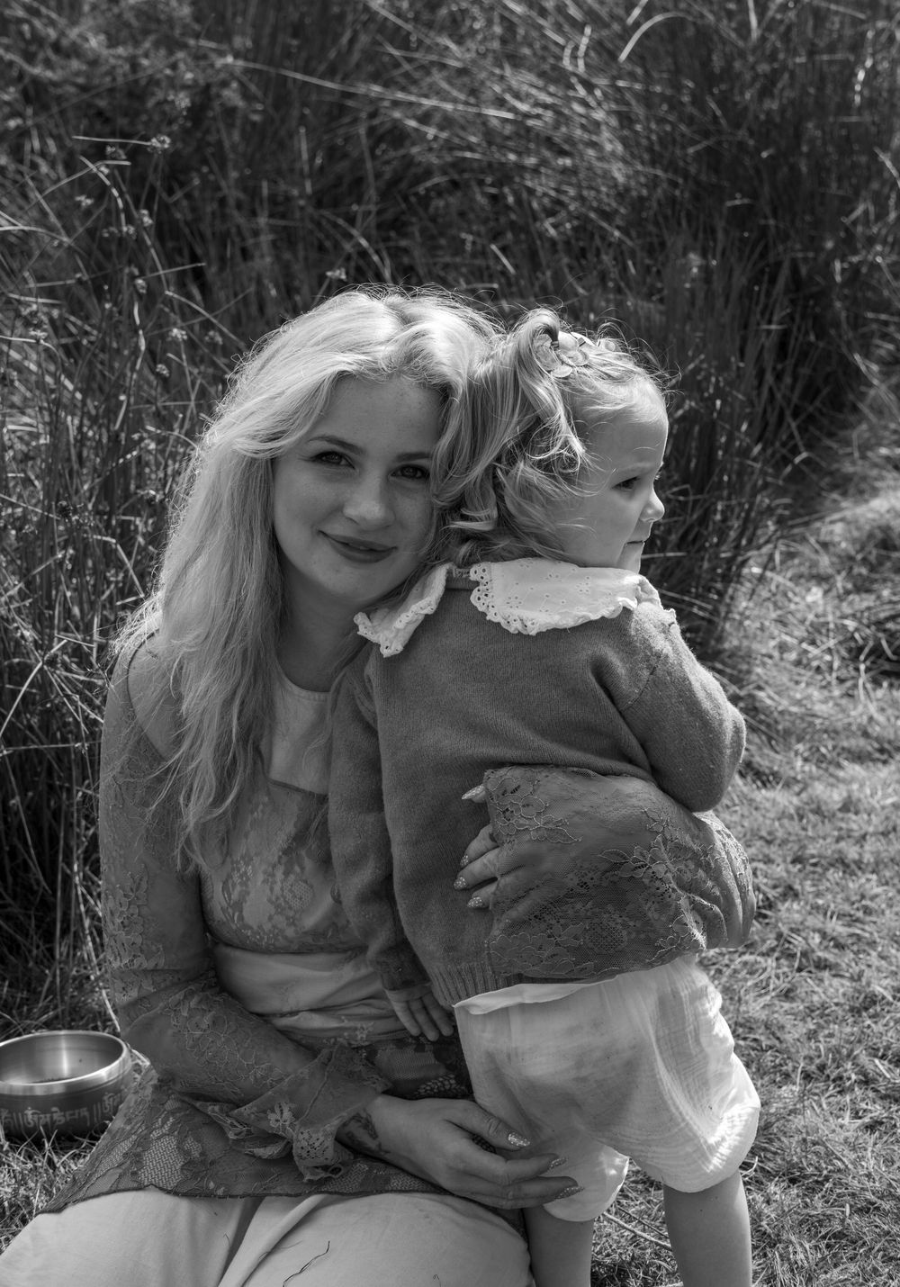 Black and white series of candid moments captured between a woman and a small child in an outdoor setting.