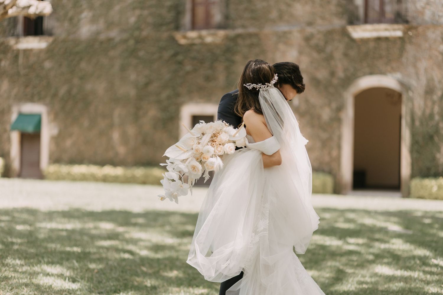 Romantic wedding couple embracing in an outdoor garden setting.