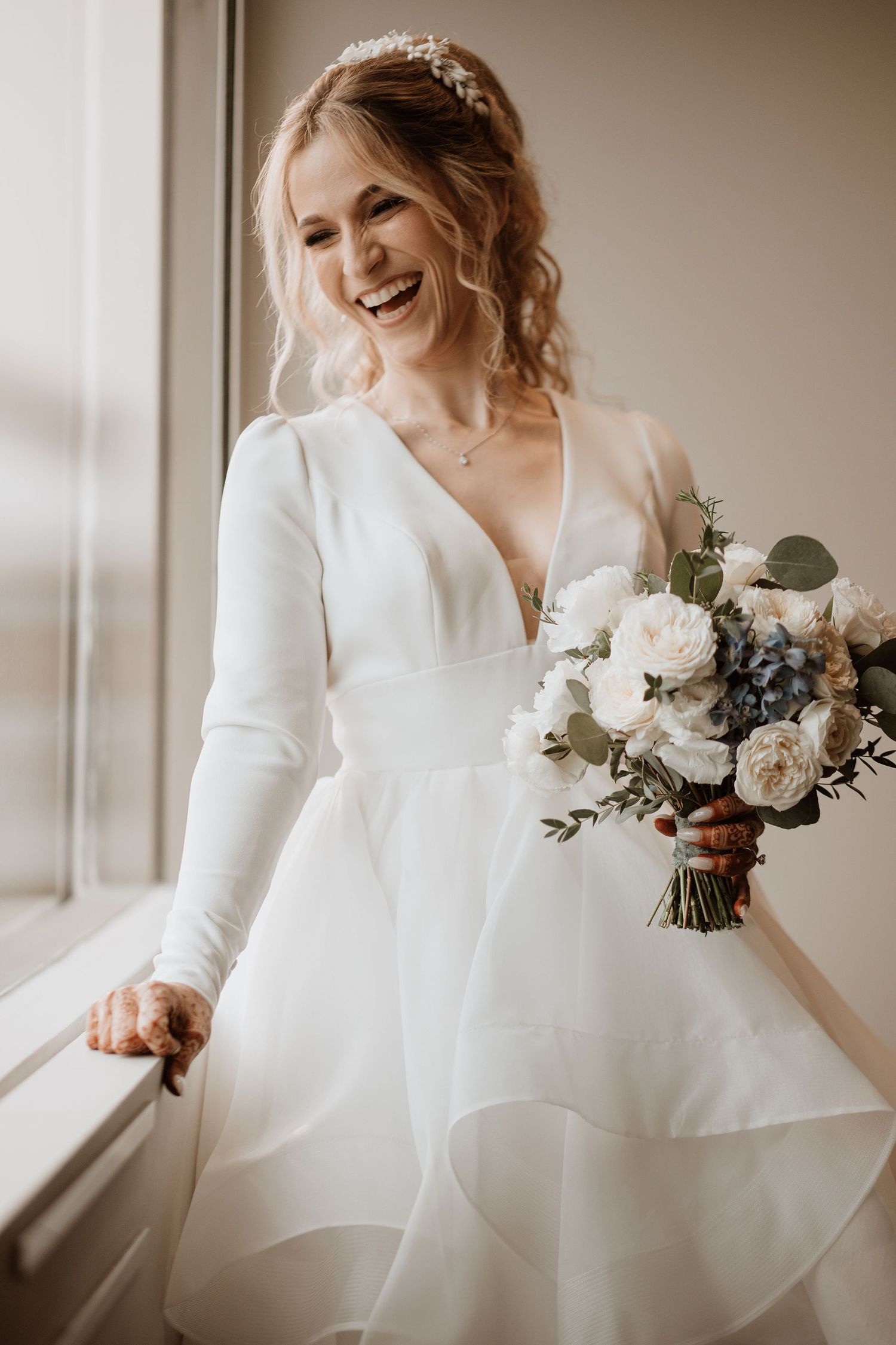 Traditional white wedding dress with long sleeves and a flowing skirt photographed in natural light.