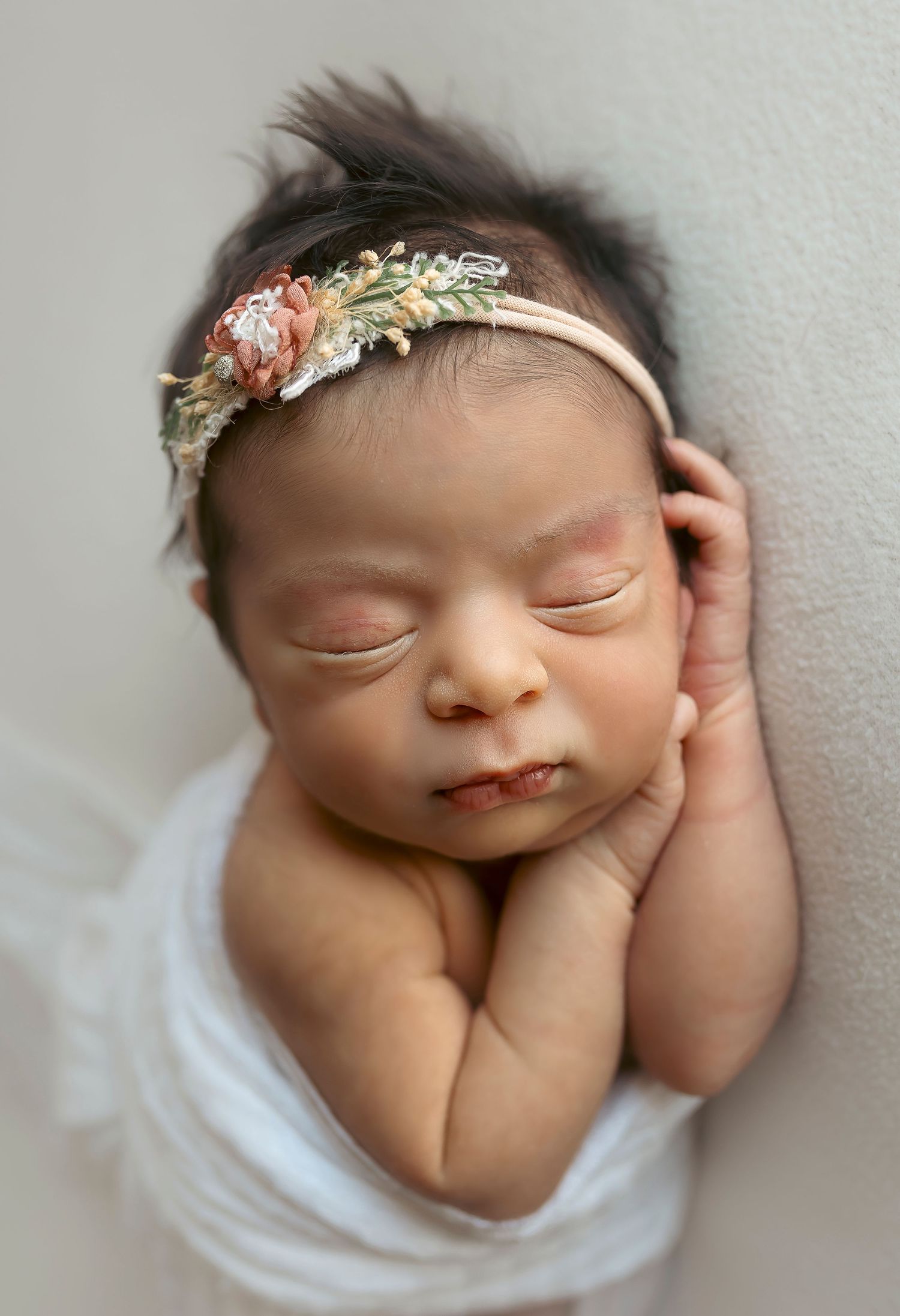 Detres photography fotografa Infanitl en Ponce Puerto Rico Fotografia de cerca de una bebe posando delado con las manitas debajo de su cara