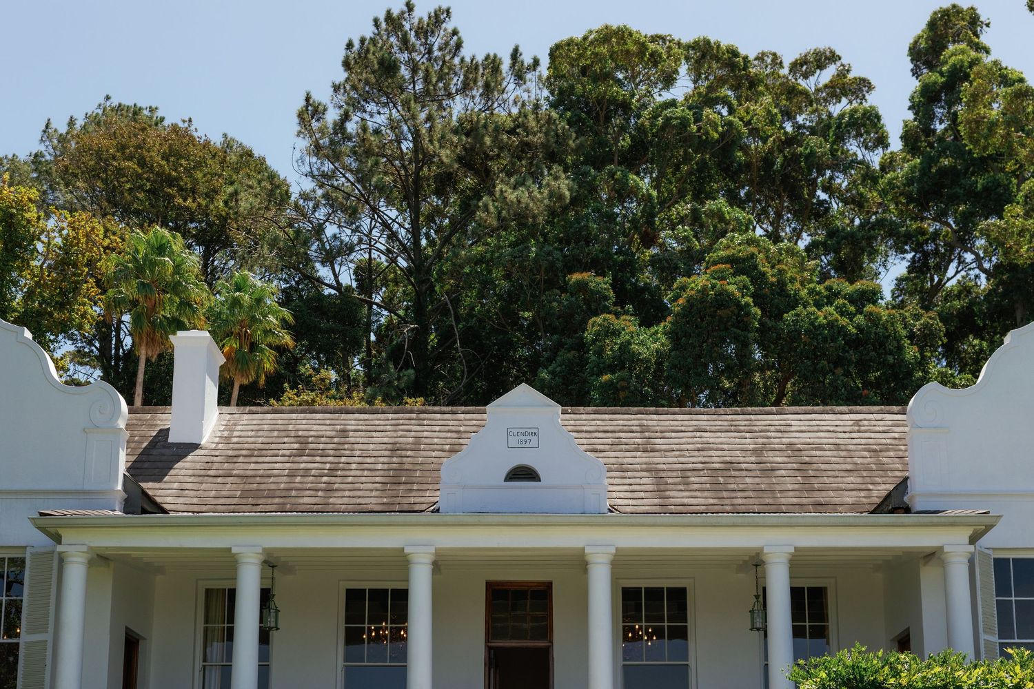 Exterior view of a white colonial-style building with classic architecture and landscaping.