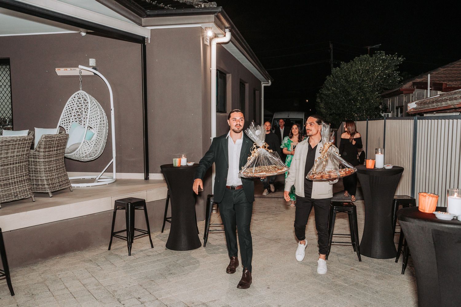 People mingling and socializing at an outdoor covered patio area.