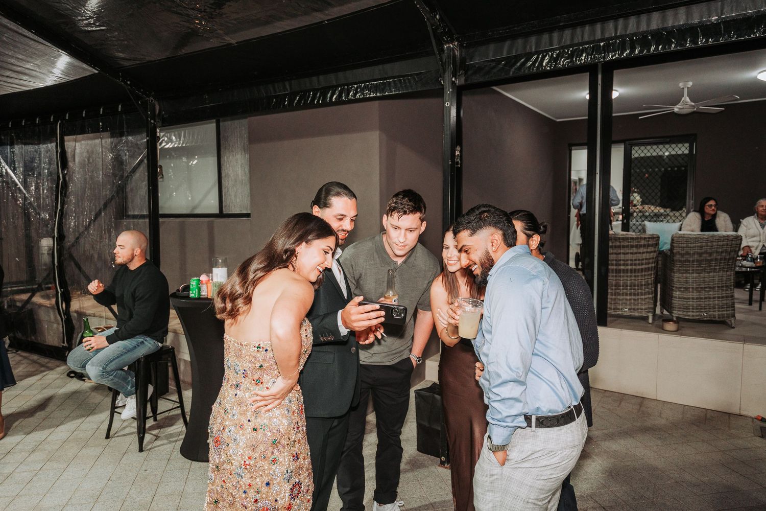 Guests enjoying a casual evening gathering at an indoor-outdoor venue space.
