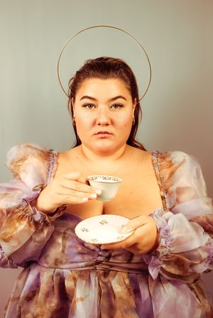 Femme regardant droit devant avec une tasse à la main et une couronne de déesse en séance studio artistique à Chazelles-sur-Lyon