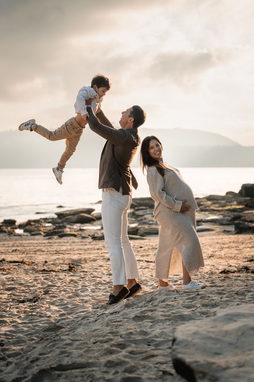 Dad throws his son into the sky while mom poses with her pregnancy bump during a family photoshoot in Sydney