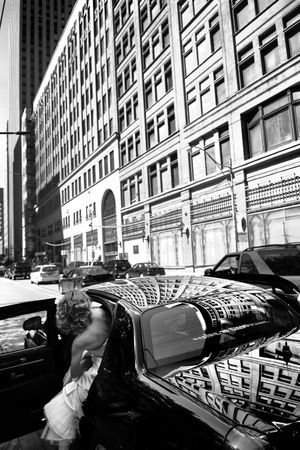 A black and white urban reflection in a car window showing a historic building facade.