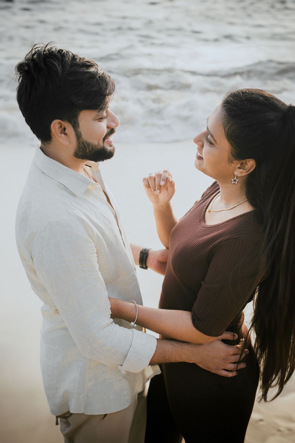 A romantic couple shares an intimate moment on the beach at sunset.