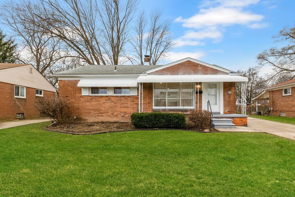 Charming brick ranch home with green lawn, covered porch, and mature trees in a quiet residential neighborhood.