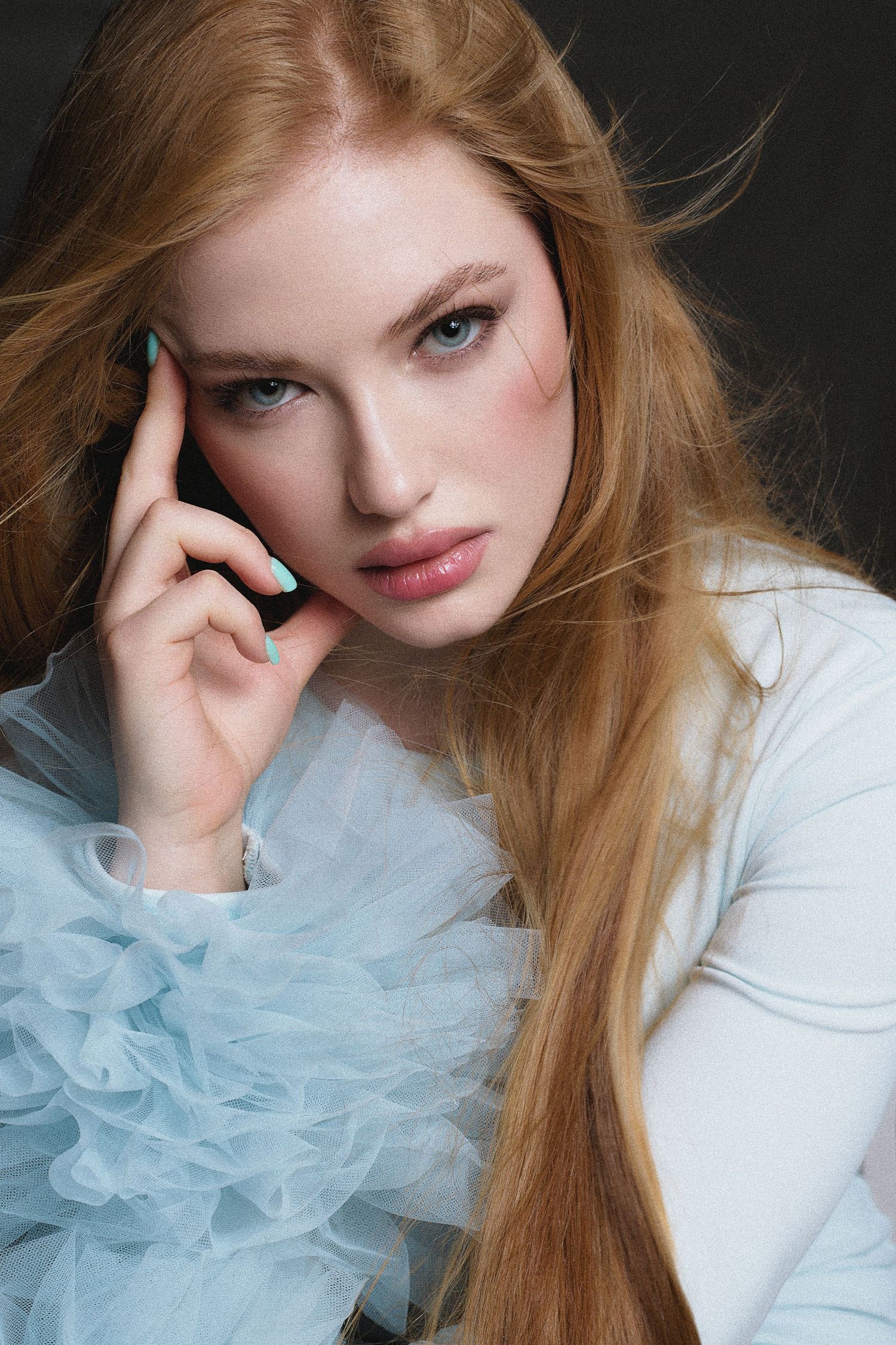 Ethereal portrait series with light blue tulle detail and soft lighting.