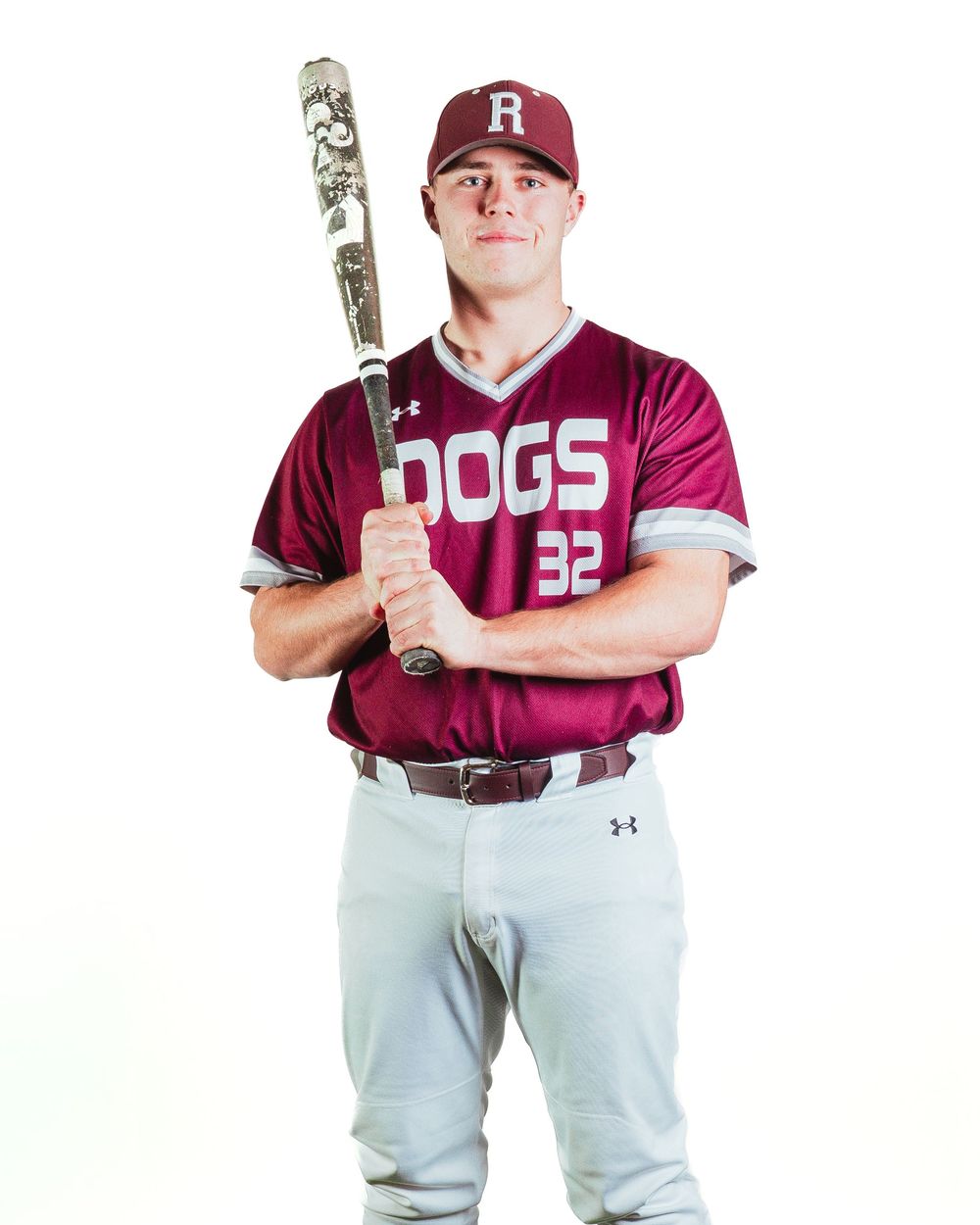 Baseball player in maroon Dogs jersey number 32 holding bat over shoulder in studio portrait photo.