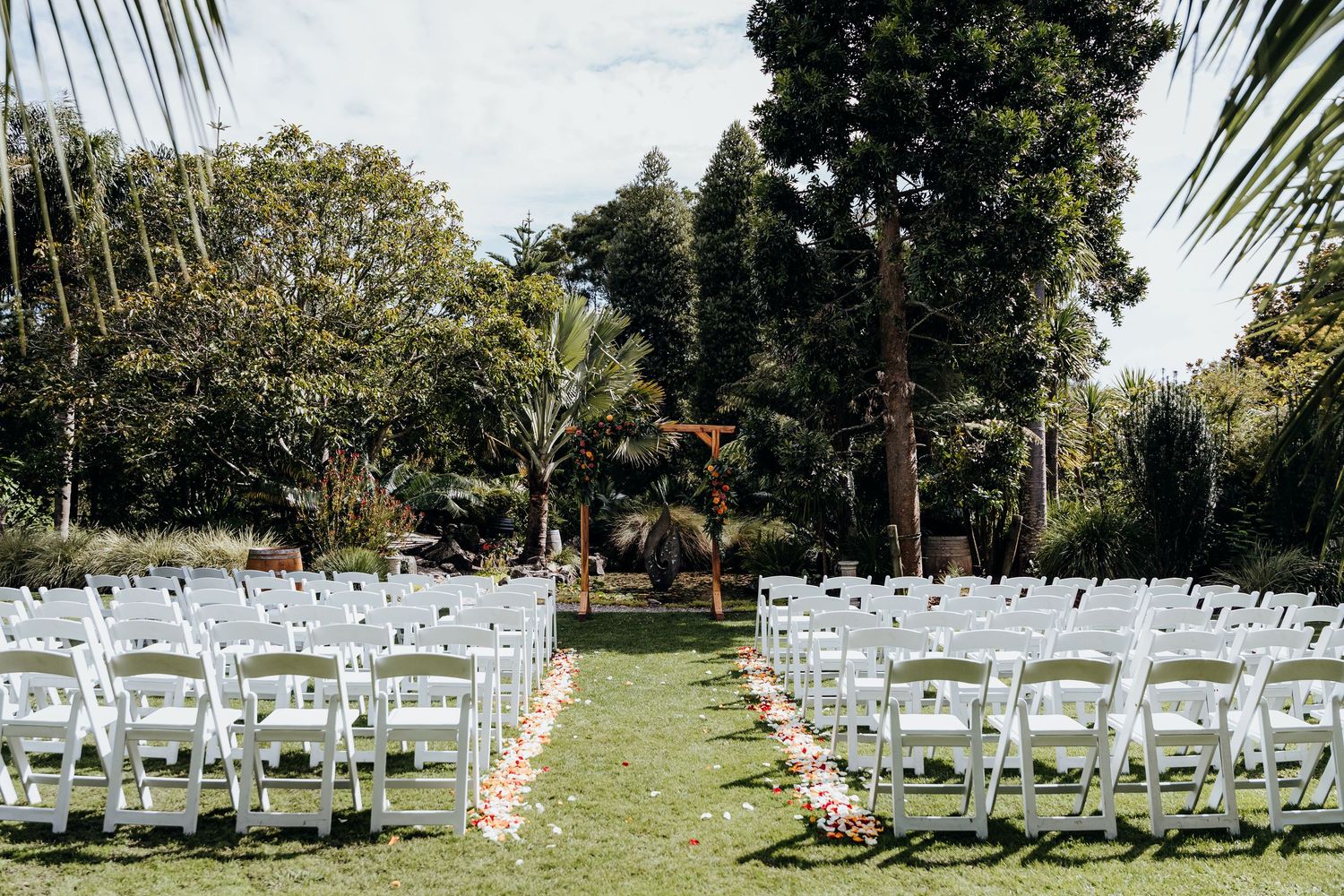 Four artistic engagement photos show a couple posing between white stone columns at a historic landmark building.