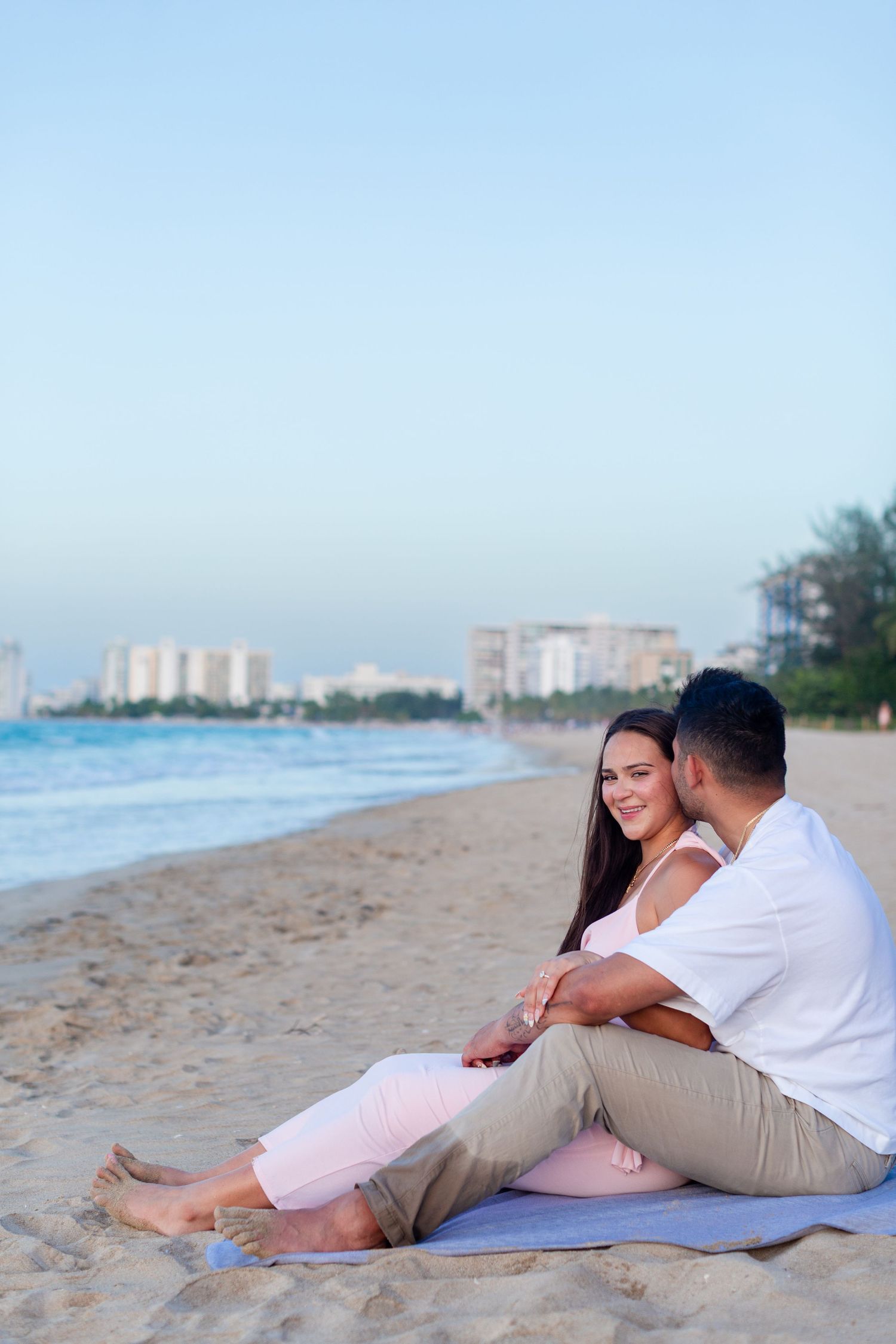 Couples portrait seated at the beach in Isla Verde, Carolina, Puerto Rico.