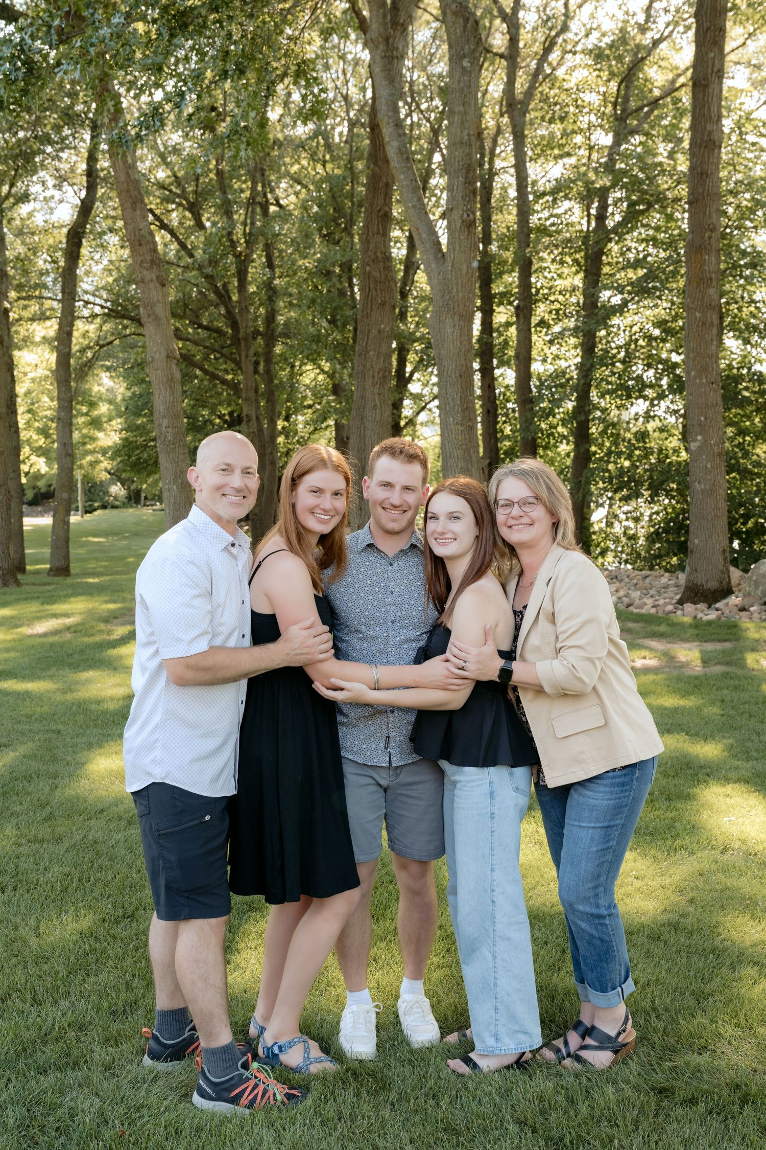 parents and three teenagers hugging for summer family portraits on lake wissota in chippewa falls wi