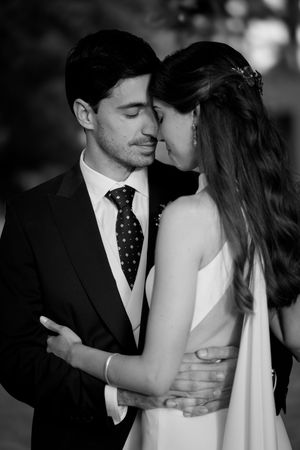 An intimate black and white portrait captures a romantic moment between newlyweds.