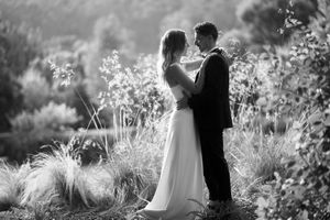 Black and white wedding portraits in a garden setting with soft natural lighting.