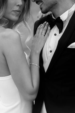 Black and white intimate portrait of couple in formal wedding attire.
