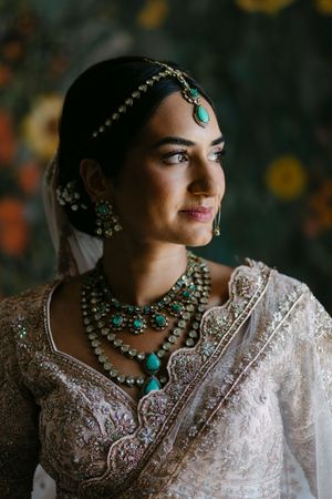 Traditional Indian bridal jewelry featuring turquoise and gold elements paired with intricate white embroidered fabric.