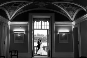 Dramatic black and white architectural wedding photos showing arched hallway and window lighting.
